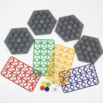 Four children laughing and playing the KidNzo Rapid Calculation math board game, using dice and colorful rings on grey numbered boards to solve equations.