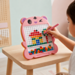 Child using magnetic pen to create colorful designs on a magnetic drawing board